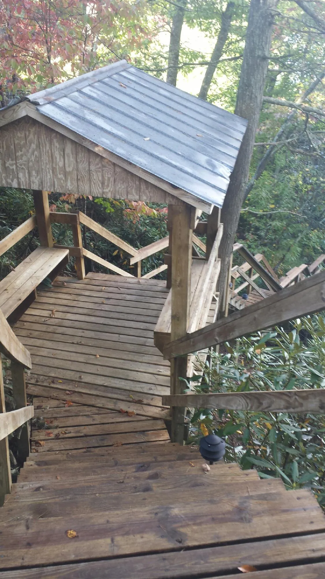 Metal roofed shelter over wooden steps on a wooded walkway — Skylight Repair & Installation work by our crew in South Milwaukee