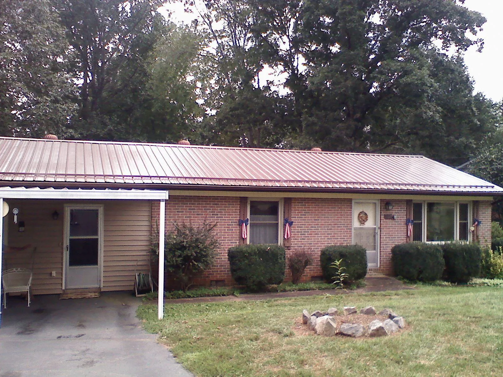 Bronze metal roof and carport on a brick ranch home — Roof Repair work by our crew in South Milwaukee