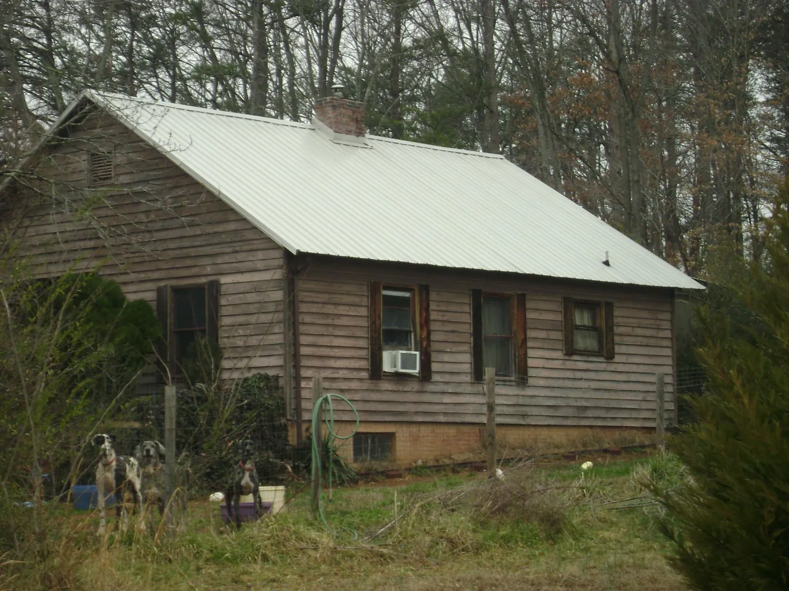 White metal roof on an old wood sided farmhouse, from a Asphalt Shingle Roof Repair job in South Milwaukee